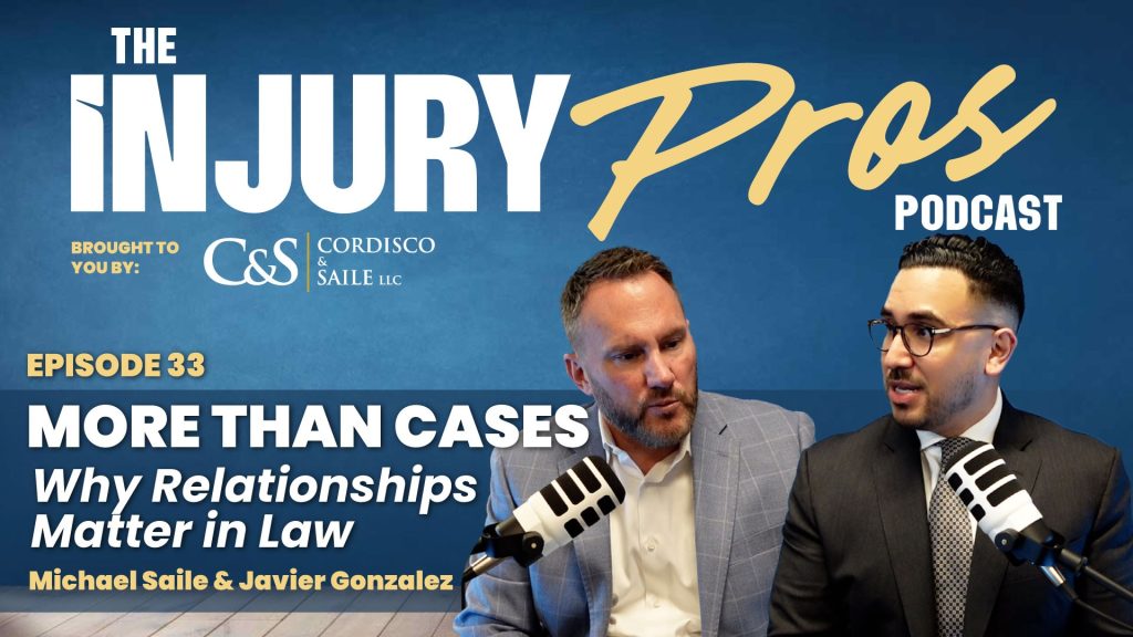 Two men in suits sit with microphones, hosting "The Injury Pros Podcast" episode 33, titled "More Than Cases: Why Relationships Matter in Law.