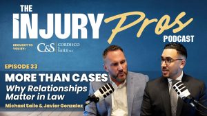 Two men in suits sit with microphones, hosting "The Injury Pros Podcast" episode 33, titled "More Than Cases: Why Relationships Matter in Law.